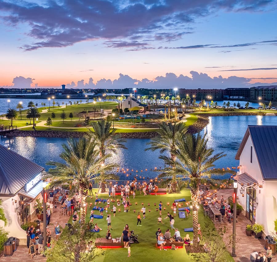 Waterfront lawn, palms and gathering spaces in Lakewood Ranch at dusk